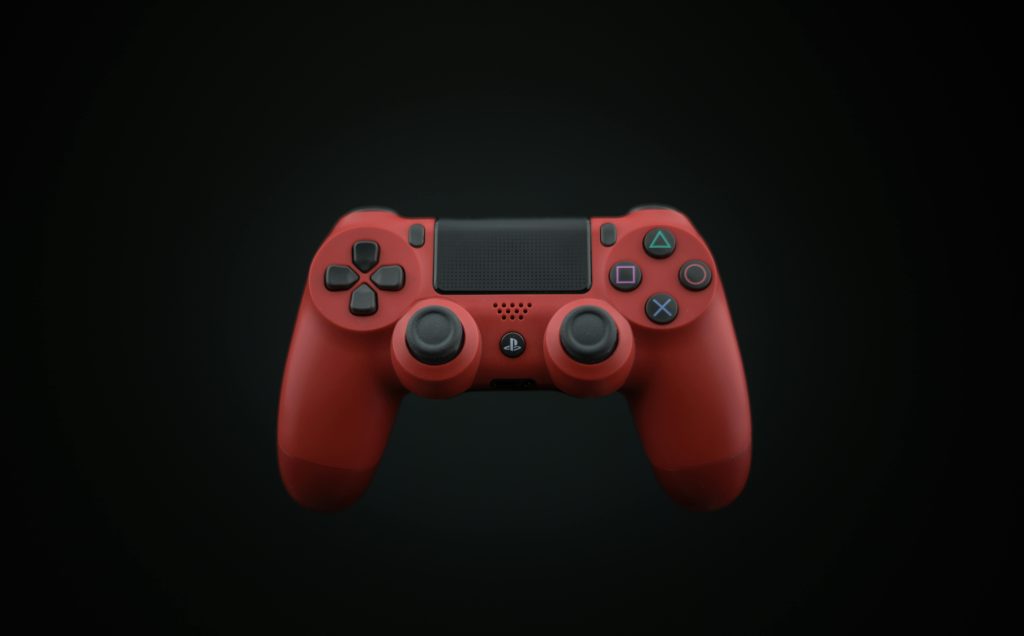 Vibrant red DualShock PS4 controller displayed on a dark background, highlighting modern gaming design.